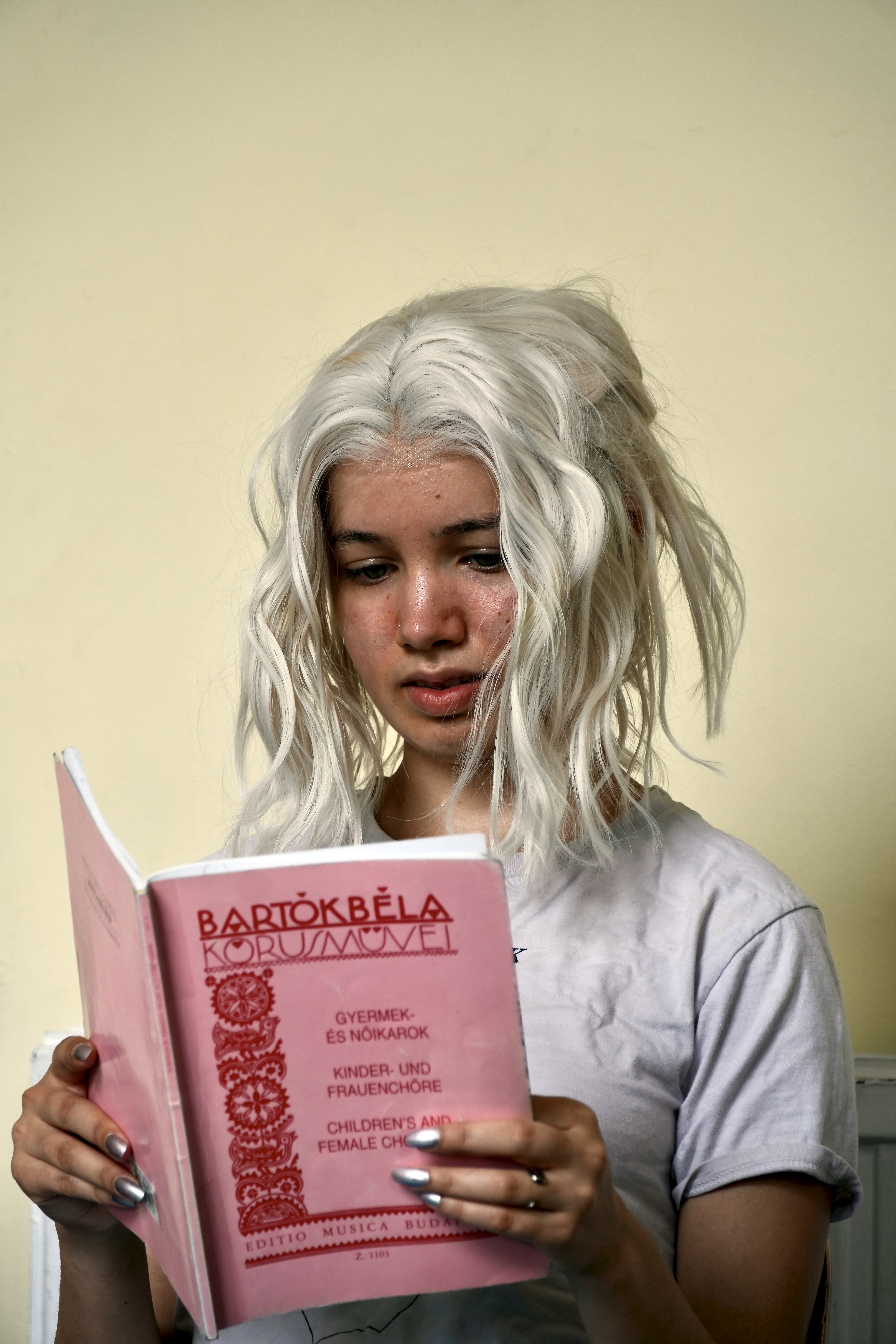 A photograph of a young woman reading a music book by Bela Bartok