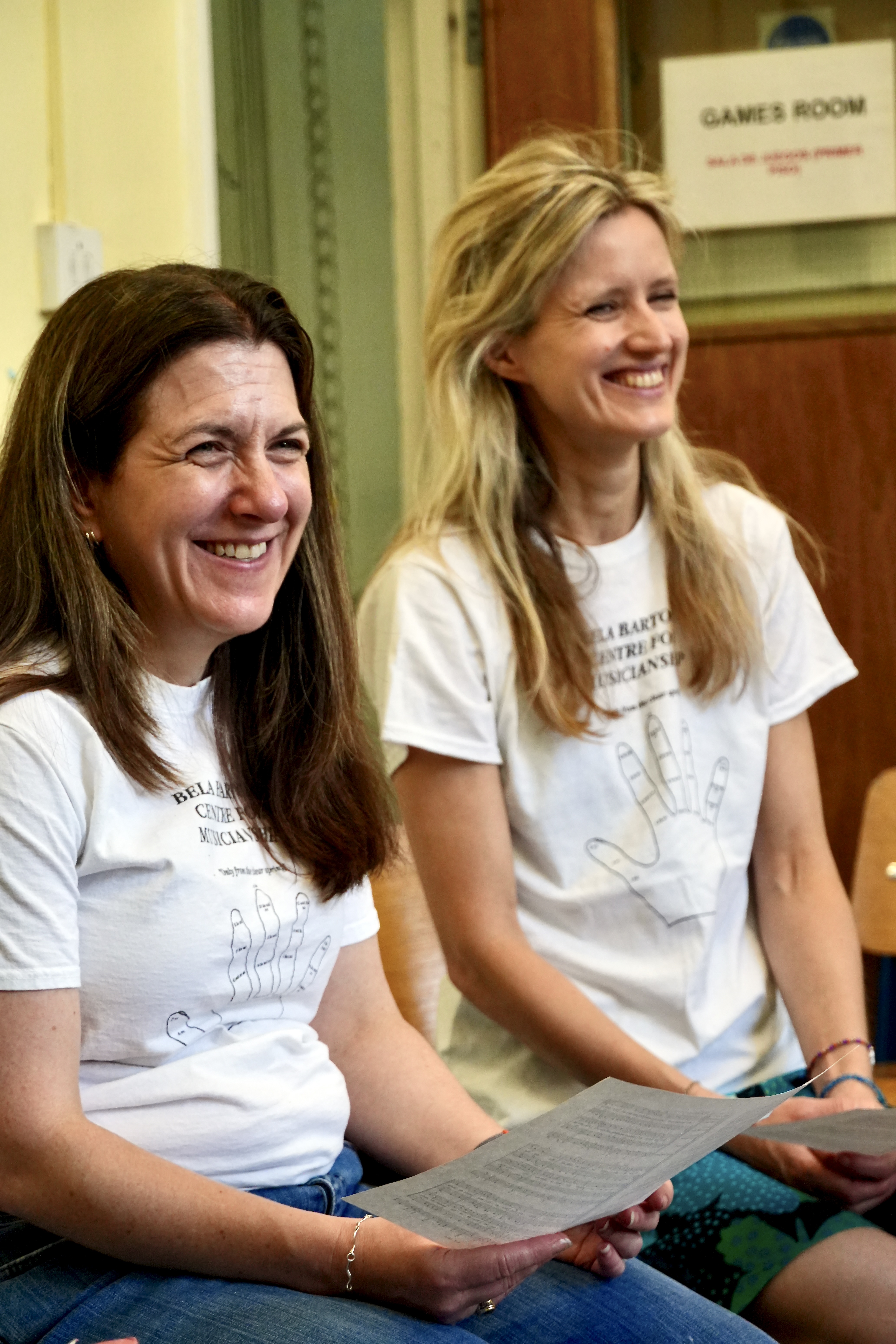 A photograph of two women, wearing BBCM t-shirts, smiling