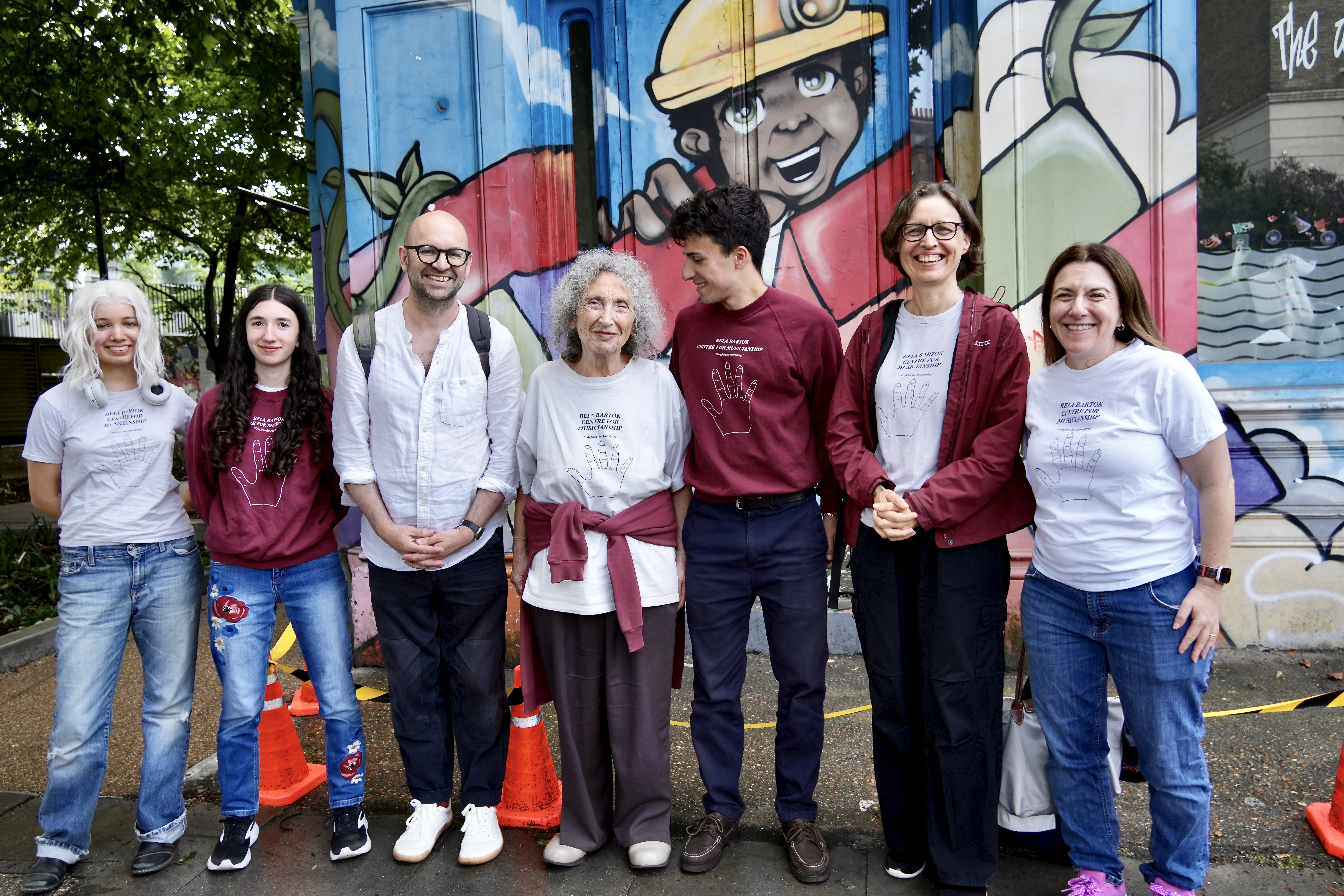 A photograph of a group of adults of varying ages, smiling at the camera.